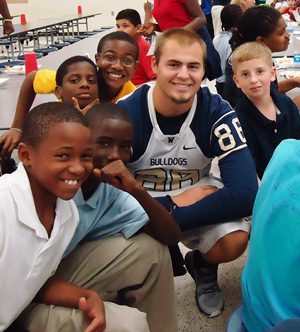 wingate football player with students 