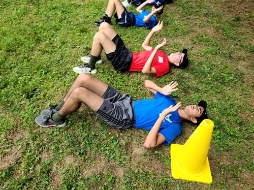 Two cadets laying on backs and pushing upward