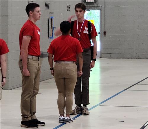 Cadet salutes camp cadet group commander after receiving a medal