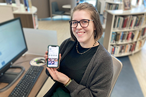  UCEC senior Meghan Sedberry holding her cell phone to show her online jewelry business